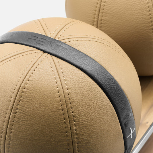 Close up of four leather medicine balls with black accent leather, arranged on two shelves made of natural wood. PENT. MOXA Power - Set of 4 Medicine Balls on Horizontal Wooden Stand