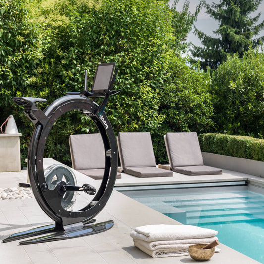 A luxury gym equipment in a luxury hotel pool area, designer exercise bike in black carbon color, handcrafted from Italy. Ciclotte Bike - Designer Exercise Bike